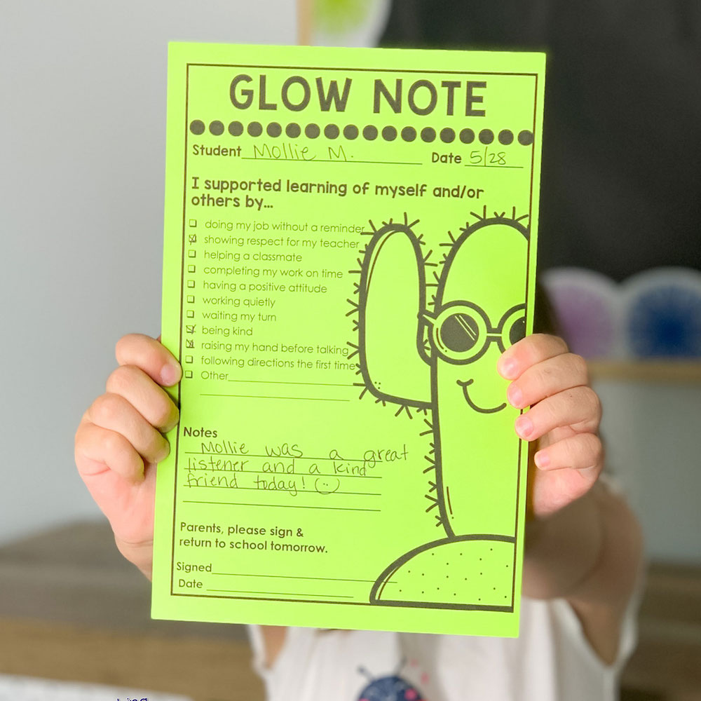 Child holding green glow notes in front of her face