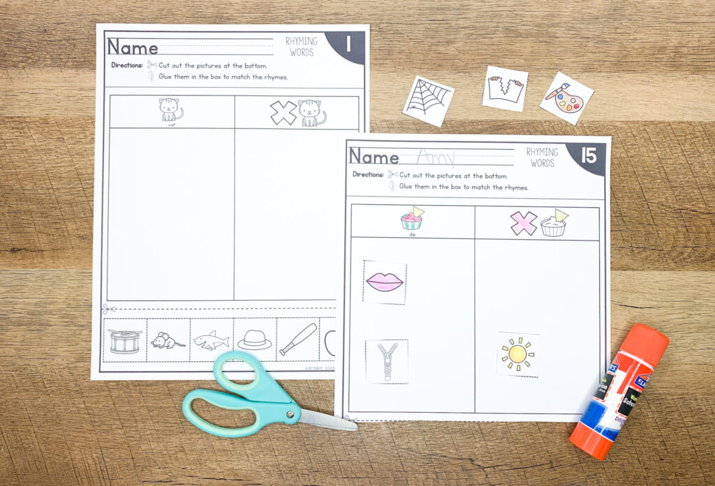 Two rhyming word sort worksheets on a desk with glue and scissors