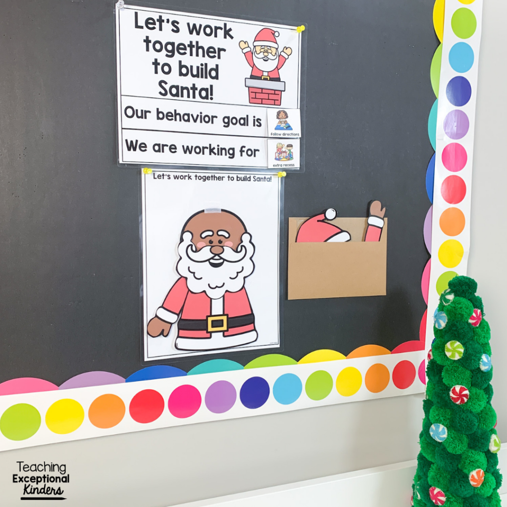 A Santa behavior chart on a bulletin board with an envelope full of Santa pieces